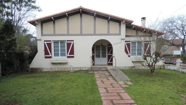 A two-story house with a central archway entrance, a small front yard, and a brick pathway leading to the door. - beautiful ronçoise villa for 7 people near the beach and shops (Ronce-les-Bains)