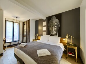 A modern hotel room with a large bed, a Buddha statue, and a view through a window. - Villa Parisiata Swimming pool, Sauna, Garden and Fitness
Exceptional location! (Puteaux)