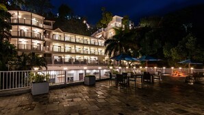 Un hotel su più piani con posti a sedere all'aperto e una zona piscina.