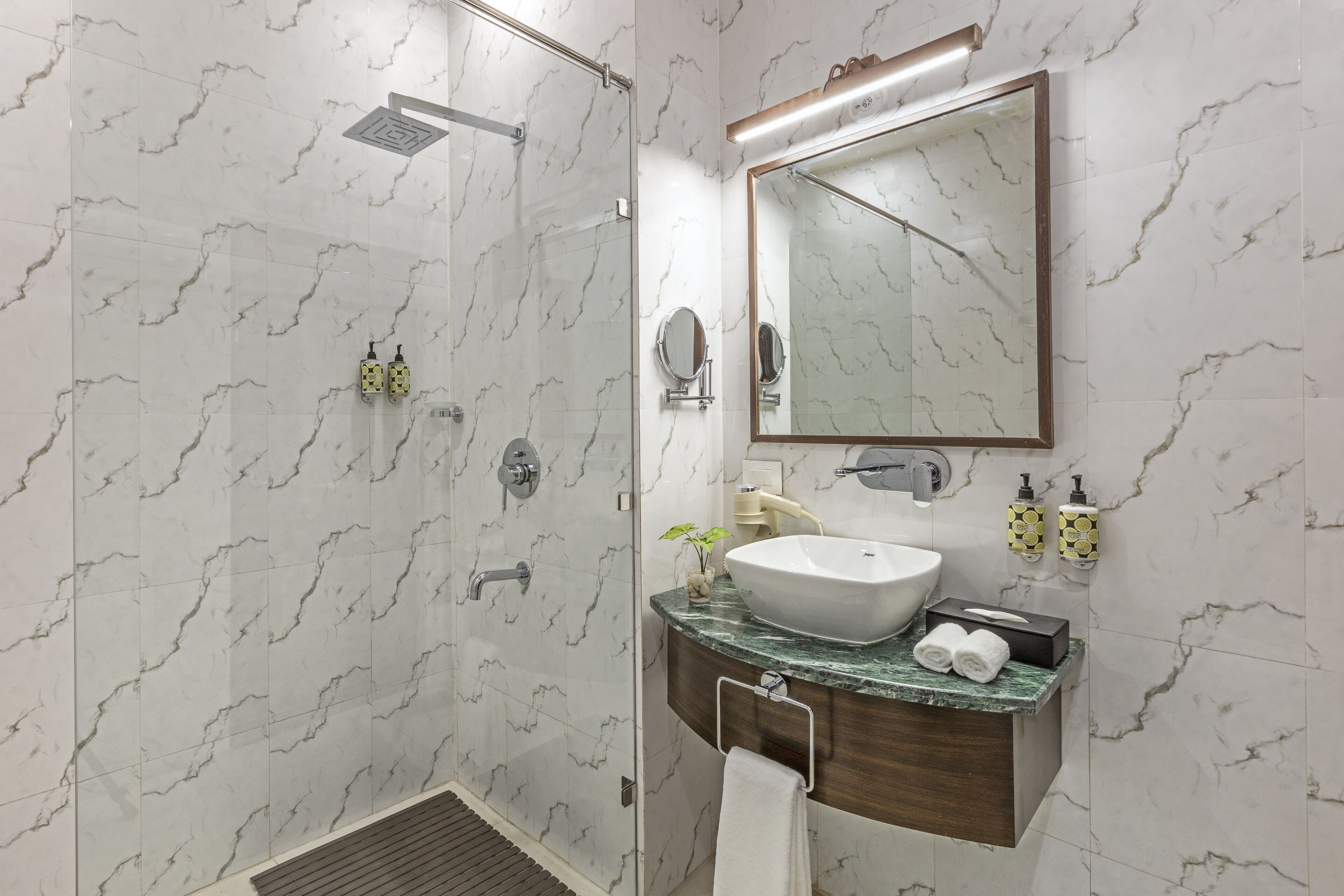 A modern bathroom with a shower, sink, and vanity.