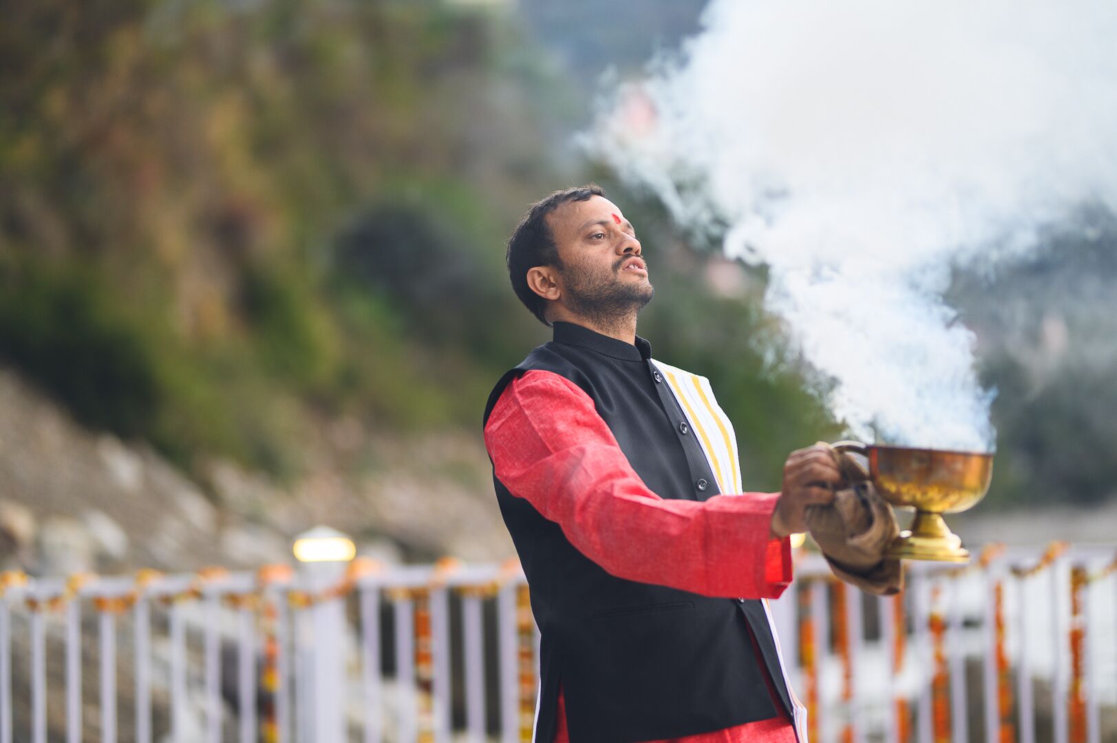 Una persona sosteniendo un cuenco ceremonial con humo elevándose.