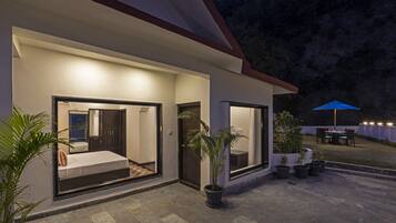 Una casa moderna con patio, ventanas amplias y plantas en macetas.