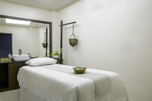 Una habitación con cama, lavamanos, espejo y lámpara colgante.