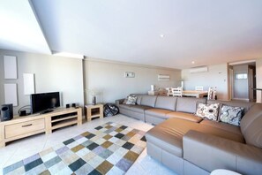 A modern living room with a sofa, television, and a patterned rug. - Apartment M311 - spacious and relaxed apartment! (Scarborough)