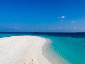 Privat strand i närheten, vit sandstrand och parasoller
