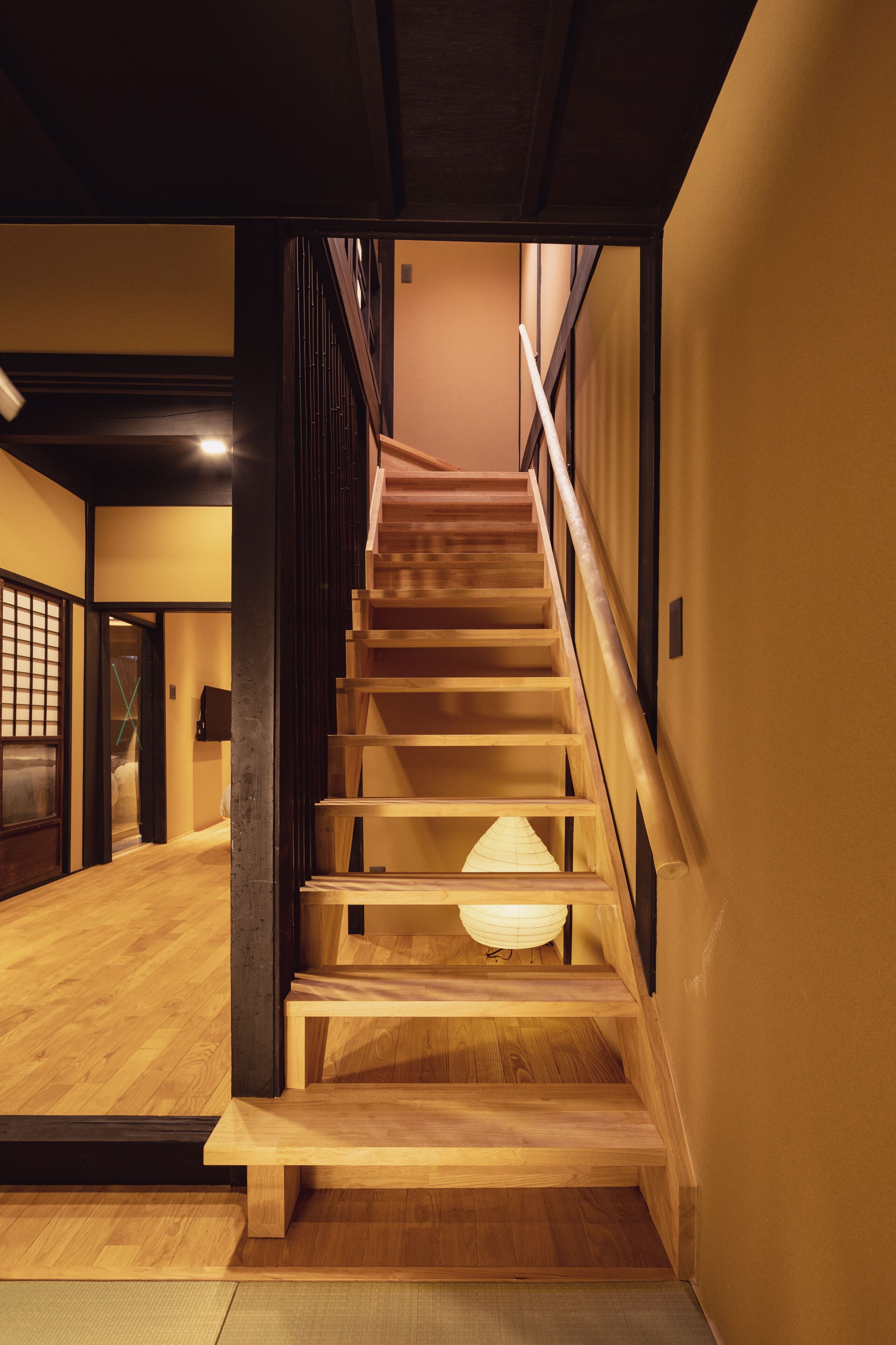 A wooden staircase with a light fixture at the bottom.