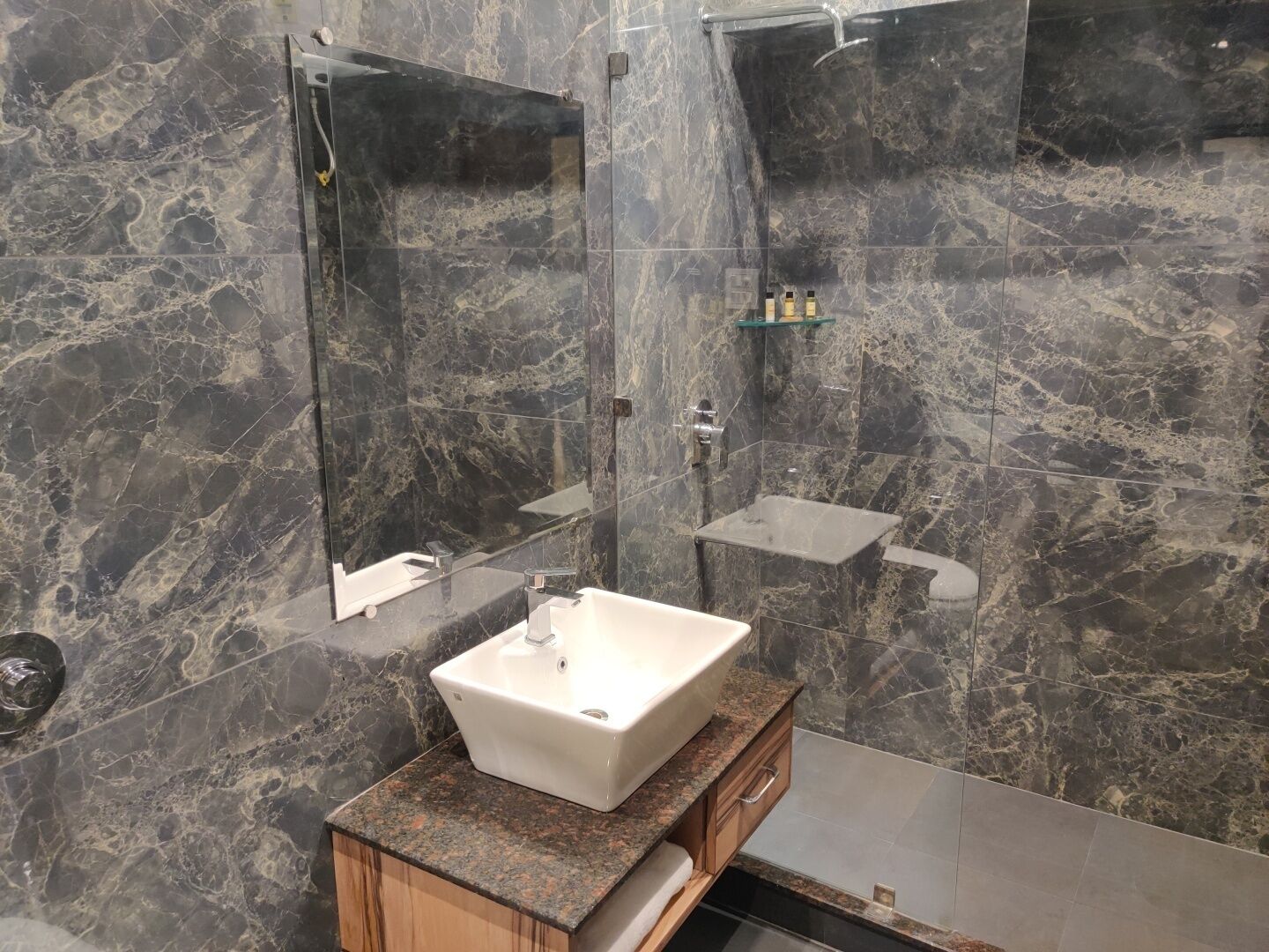Un baño moderno con un espejo grande, un lavabo blanco y una zona de ducha.