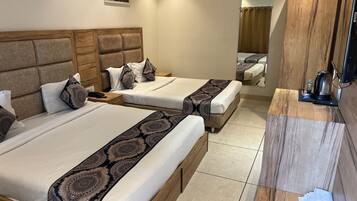 Une chambre d’hôtel avec deux lits, une tête de lit en bois, une table de chevet avec une lampe et un miroir.