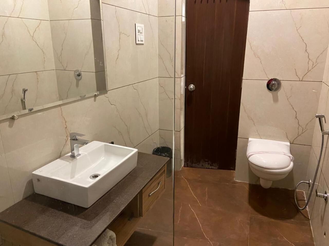 Un bagno con un lavandino bianco, un water e uno spazio doccia.