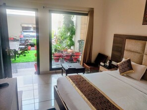 Une chambre d’hôtel équipée d’un lit, d’un bureau, d’une chaise, d’une machine à café et offrant une vue sur l’extérieur.