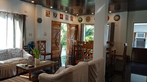 Ein Wohnzimmer mit einer Couch, einem Couchtisch und einem Essbereich mit Stühlen und einem Tisch.