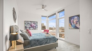 Una camera da letto con un letto, un comodino, una lampada e una ventola a soffitto.