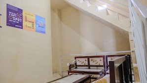 A hotel room with a bed, a desk, and a chair. There are posters on the wall. - SPOT ON 2387 Bukit Cemara Tidar Family (Malang)