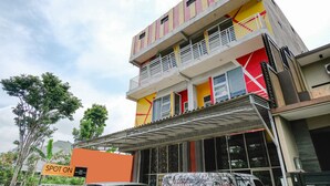 A multi-story building with a colorful facade, balconies, and a sign indicating it is a hotel. - SPOT ON 2387 Bukit Cemara Tidar Family (Malang)