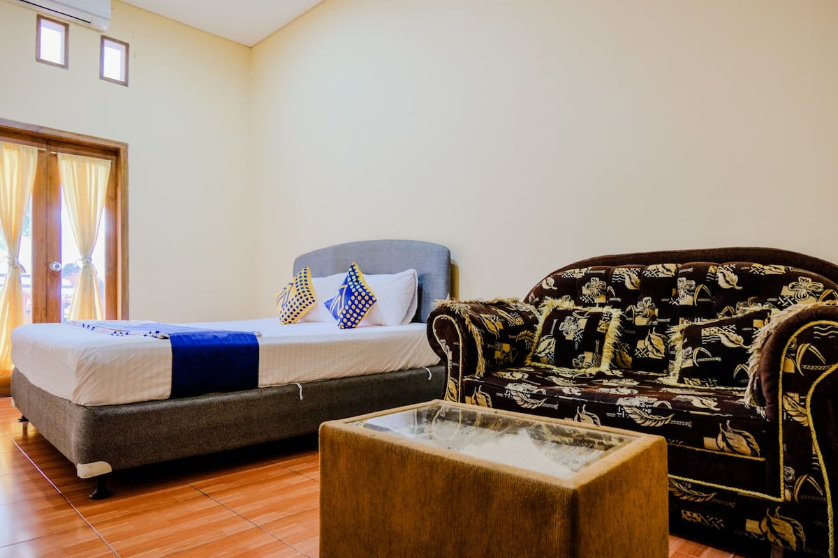 Una habitación con una cama, un sofá y una mesa de centro.