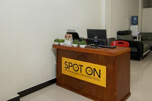 A reception desk with a sign reading "SPOT ON AFFORDABLE AND CONVENIENT HOTEL". - OYO 2220 PINK'S GUEST HOUSE (Hutagodang)