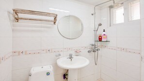 A bathroom with a white sink, a mirror, a shower, and a toilet. - Vellise Pension (Taean)