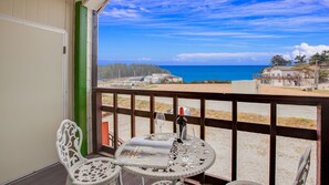 A balcony with a table, chairs, and a bottle of wine. - Vellise Pension (Taean)