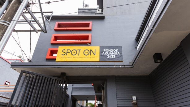 A hotel sign with the name 'Pondok Akuanna 2433' and a 'Spot On' label indicating it is affordable and convenient. - SPOT ON 2433 Pondok Akuanna (Makassar)