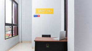 A room with a desk, a chair, a window, and a sign that says "SPOT ON" with a "Free Wi-Fi" symbol. - SPOT ON 2433 Pondok Akuanna (Makassar)