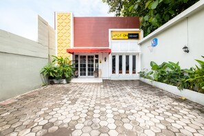 A hotel entrance with a tiled hexagonal floor, a red awning, and a sign reading "SPOT ON". - SPOT ON 2419 Rumah Nugraha Hotel Syariah (Yogyakarta)