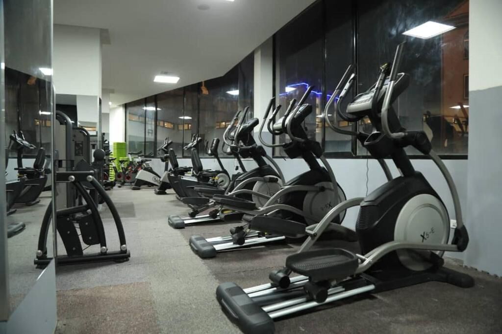 Un gimnasio con varias cintas de correr dispuestas en filas.