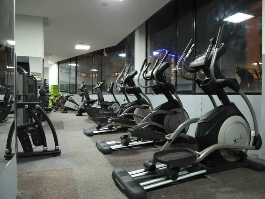Un gimnasio con varias cintas de correr dispuestas en filas.