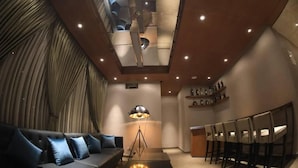 Un intérieur moderne comprenant un canapé, une table à manger et des chaises, un lampadaire et un escalier.