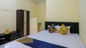 Ein Hotelzimmer mit Bett, Kleiderschrank und Schreibtisch.