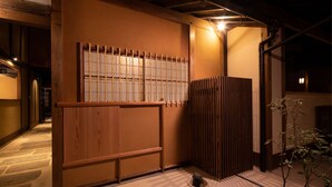 A traditional Japanese interior with tatami flooring, a sliding door, and a small stone lantern.