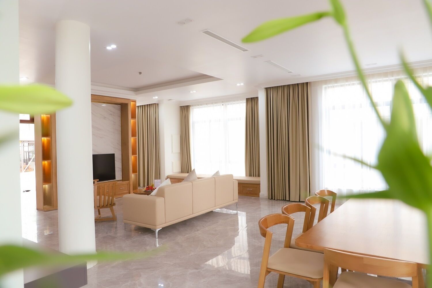 A modern living room with a sofa, TV, and dining area.