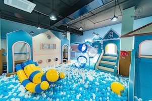 Zona de juegos infantiles con piscina de pelotas, toboganes y estructuras recreativas.