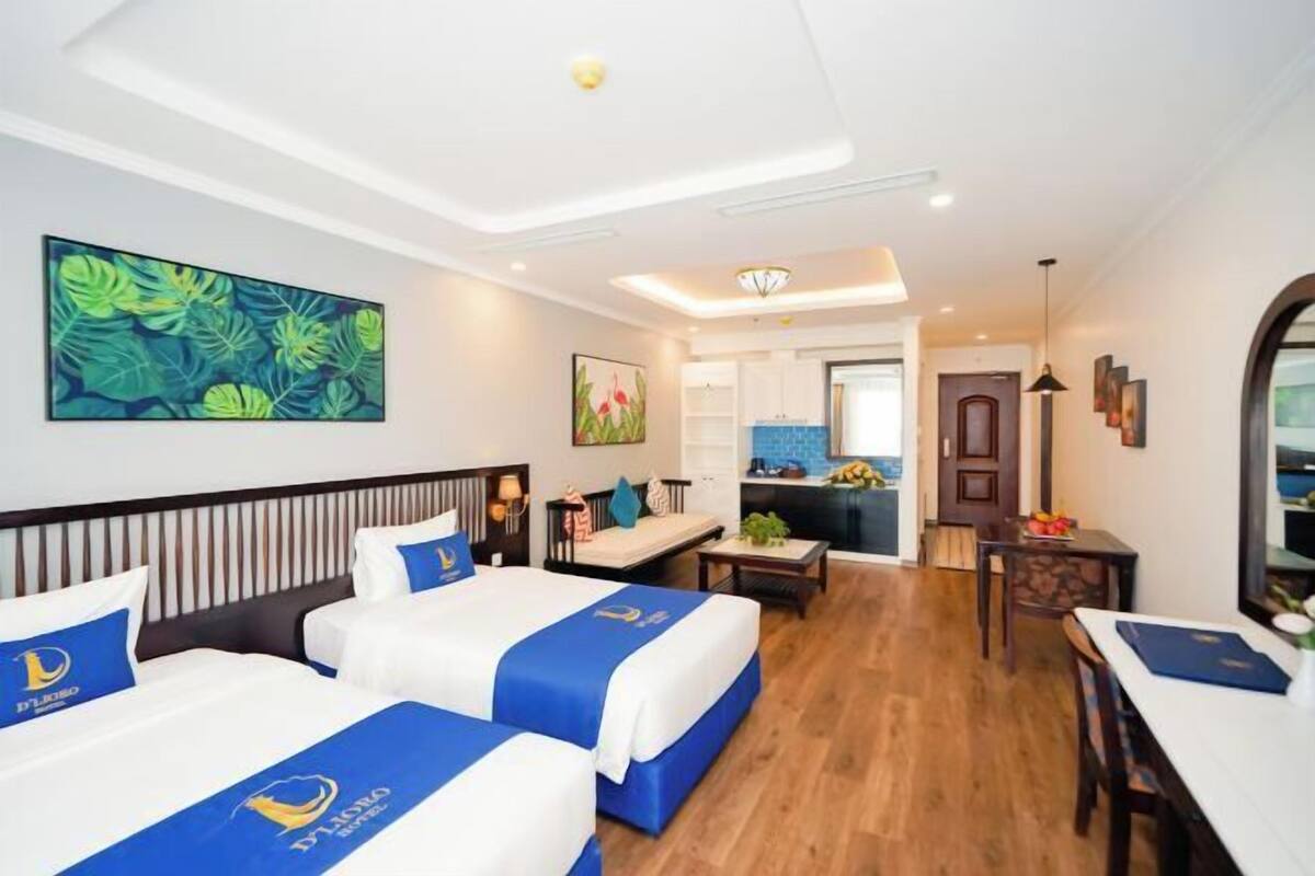 Une chambre d’hôtel avec deux lits, une kitchenette, un coin repas et une salle de bain.