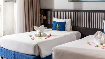 Habitación de hotel con dos camas, cabecero con listones verticales y un cuadro sobre las camas.