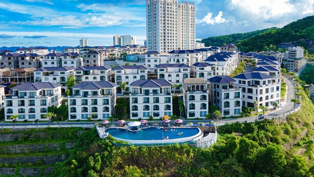 A residential area with a swimming pool surrounded by multi-story buildings, including a hotel.