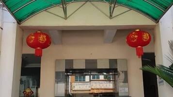 The entrance of Desa Inn with a green awning and red lanterns.