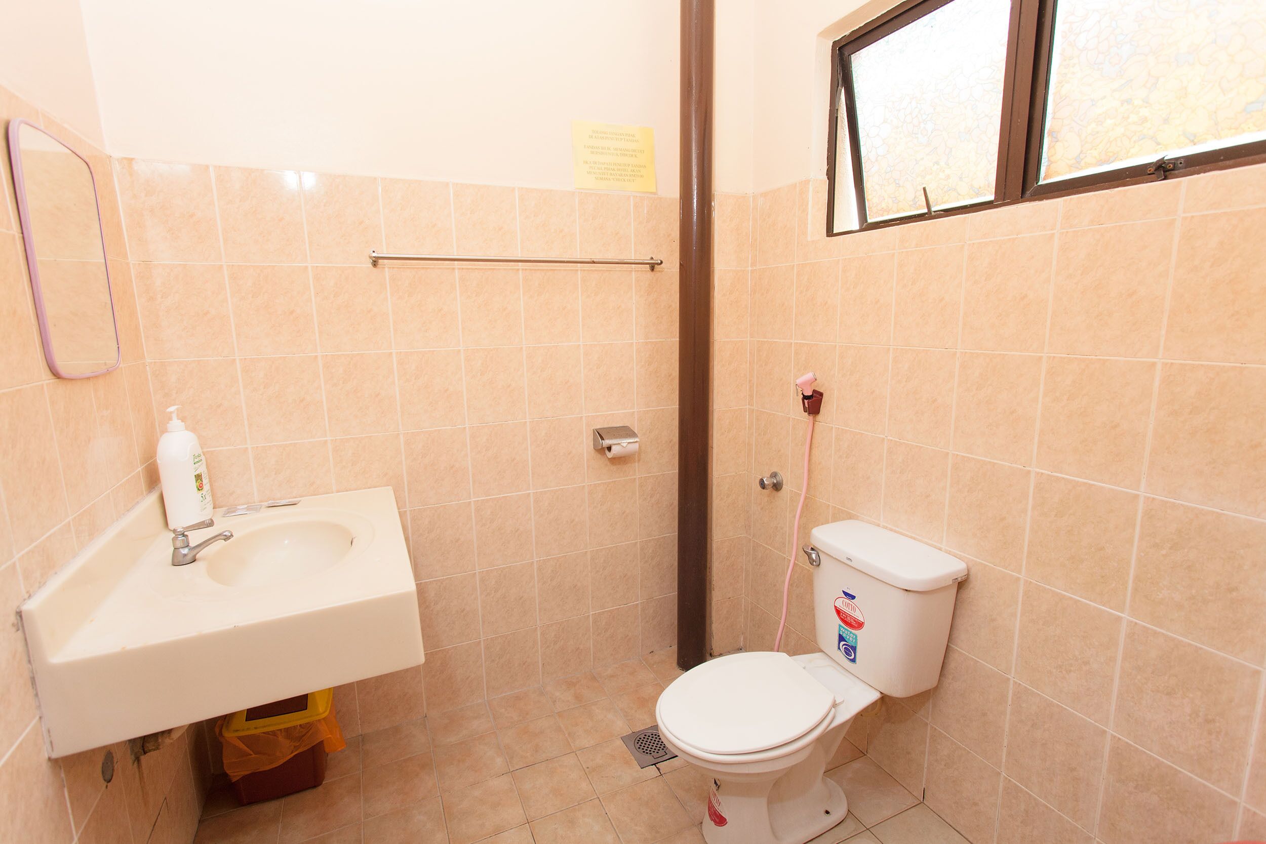 Uma casa de banho pequena com lavatório, sanita e janela.