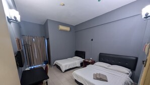 A hotel room with two single beds, a small table, and a chair. - Desa Inn Hotel (Kuala Pilah)