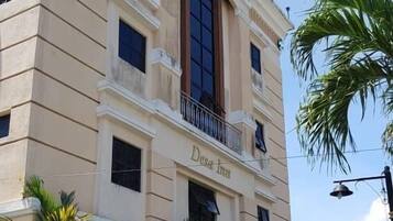 A building with a sign reading "Dasa Inn" and a balcony.