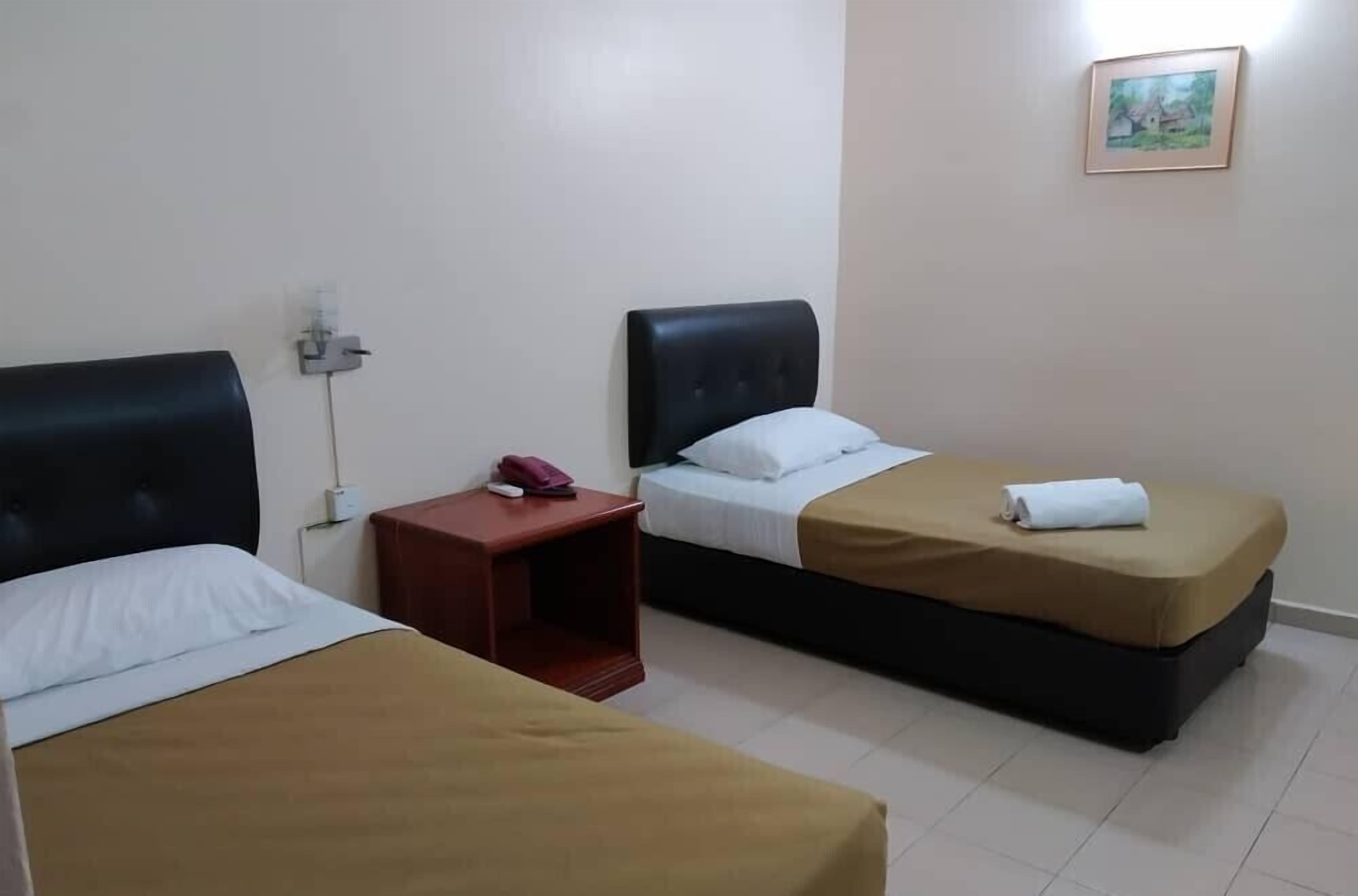 A hotel room with two beds, a nightstand, a phone, and a painting on the wall.