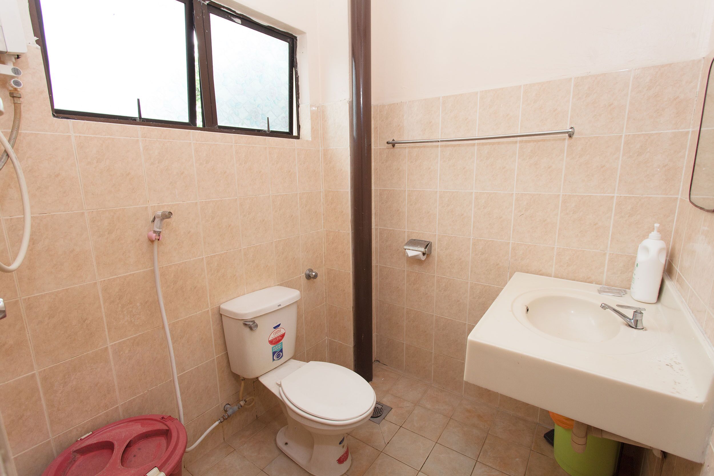 Un bagno con il water, un lavandino e una finestra.