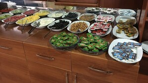 Een buffet met diverse gerechten en bijbehorende sauzen.
