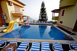 Piscine extérieure, parasols de plage, chaises longues