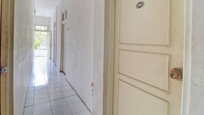 A hallway with a door marked "201" leading to a bright room. - OYO 2452 Hotel Metro (Bandung)