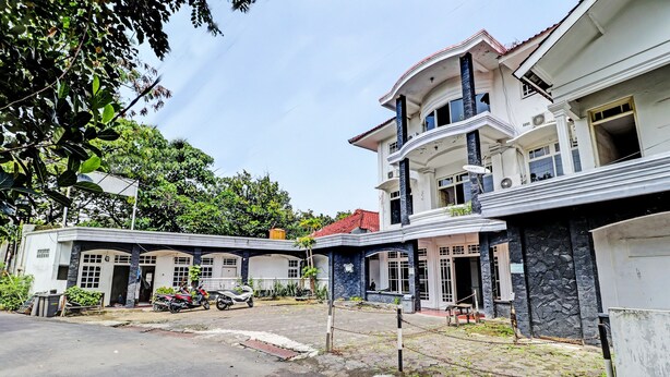 A residential building with a two-story structure, a balcony, and a stone facade. - OYO 2452 Hotel Metro (Bandung)