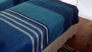 A bedroom with two beds, a wardrobe, a mirror, and a small desk. - Campismo Ninho 11 (Ponta d'Ouro)