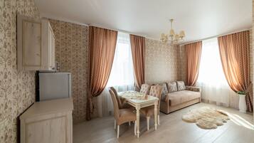 Habitación Deluxe | Área de sala de estar | Televisión de pantalla plana de 42 pulgadas con canales vía satélite