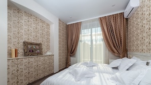 Una habitación de hotel con una cama, un cuadro en la pared y cortinas.