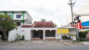 A building with a red-tiled roof and a white facade. - OYO 2454 Wanawiyata Homestay  (Depok)