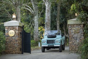 Drive through the gates of Hanthana Estate Kandy, where lush greenery surrounds an entrance.